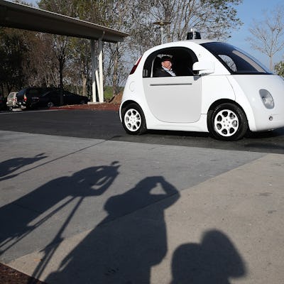 A man sitting in a driverless white car 