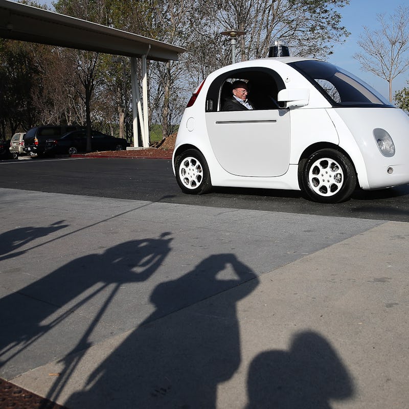 A man sitting in a driverless white car 