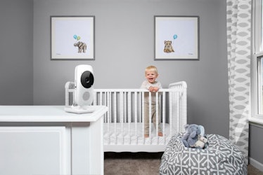 A baby video monitor next to a baby bed
