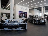 Tesla prototype vehicle next to Tesla model S vehicle at a Tesla showroom
