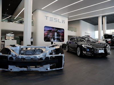 Tesla prototype vehicle next to Tesla model S vehicle at a Tesla showroom