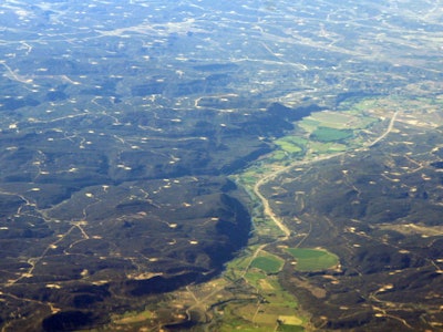 An aerial shot of a landscape of the Southwest with giant methane plumes