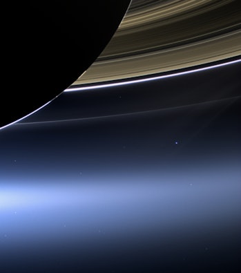 Saturn, from Cassini's perspective, along with a tiny bright dot below the rings that is Earth.