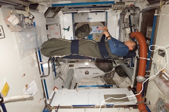 An astronaut sleeps in the International Space Station.