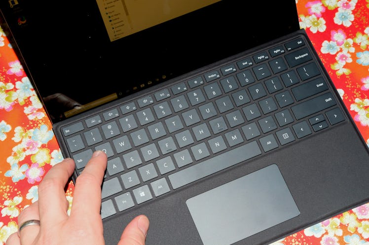 A person using the Microsoft Surface Pro X laptop