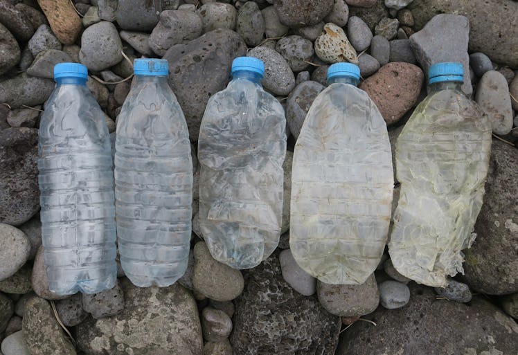 Five plastic bottles on a rock beach