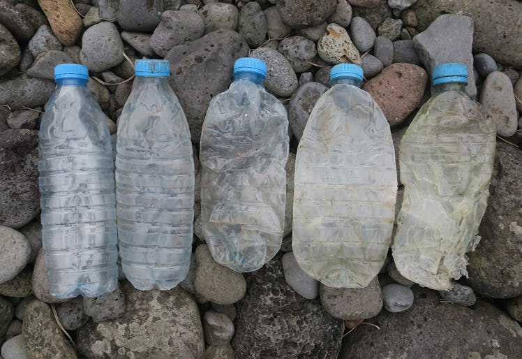 Five plastic bottles on a rock beach
