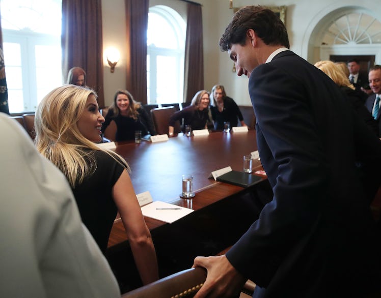 Canadian Prime Minister Justin Trudeau (R) helps Ivanka Trump with he chair during a roundtable disc...