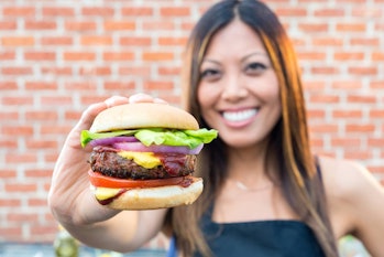 A woman holds the Beyond Burger, a patty made from plant proteins by meat alternative producer Beyon...