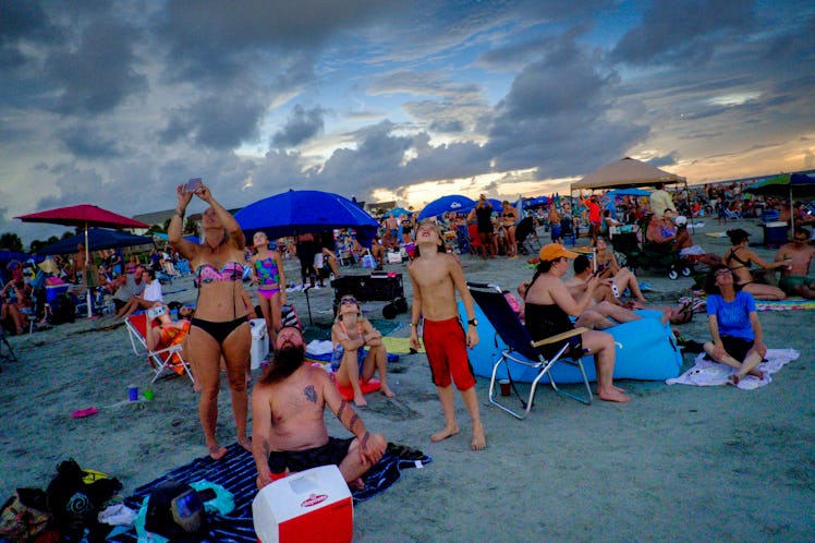 A group of Americans at a beach watching the eclipse