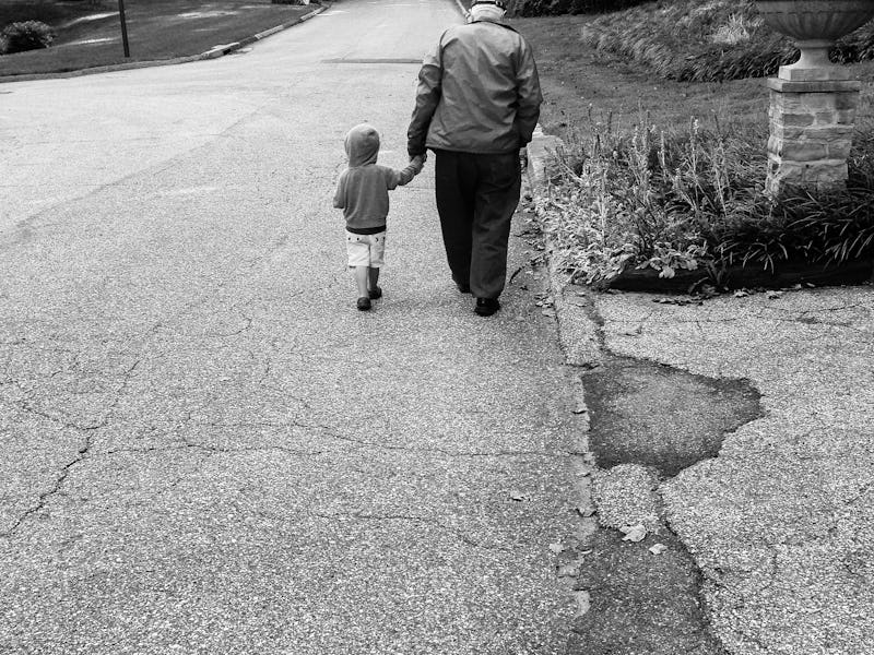 Grandpa walking with his grandchild down a forest road