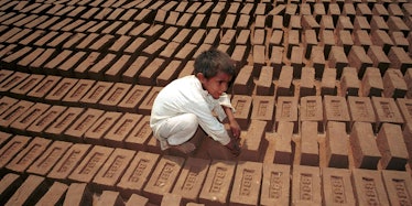A young Pakistani boy lays bricks.