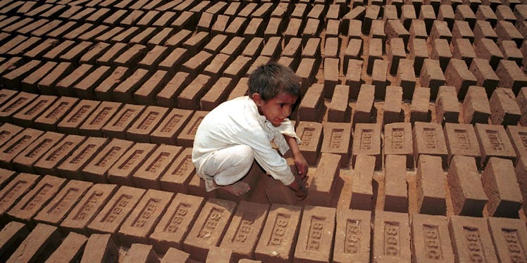 A young Pakistani boy lays bricks.