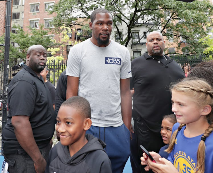 Kevin Durant at an outdoor basketball court surrounded by kids