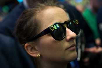 A woman wears 'Snapchat Spectacles' on the floor of the New York Stock Exchange (NYSE).
