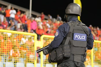 PORT OF SPAIN, TRINIDAD & TOBAGO - NOVEMBER 17: A policeman in full riot gear keeps a close eye duri...