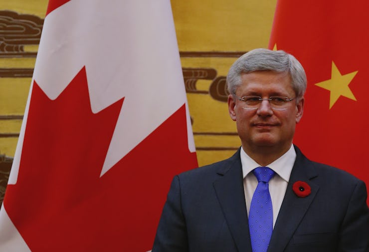 Prime Minister Stephen Harper standing in front of a Canadian flag