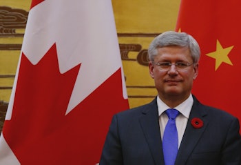 Prime Minister Stephen Harper standing in front of a Canadian flag