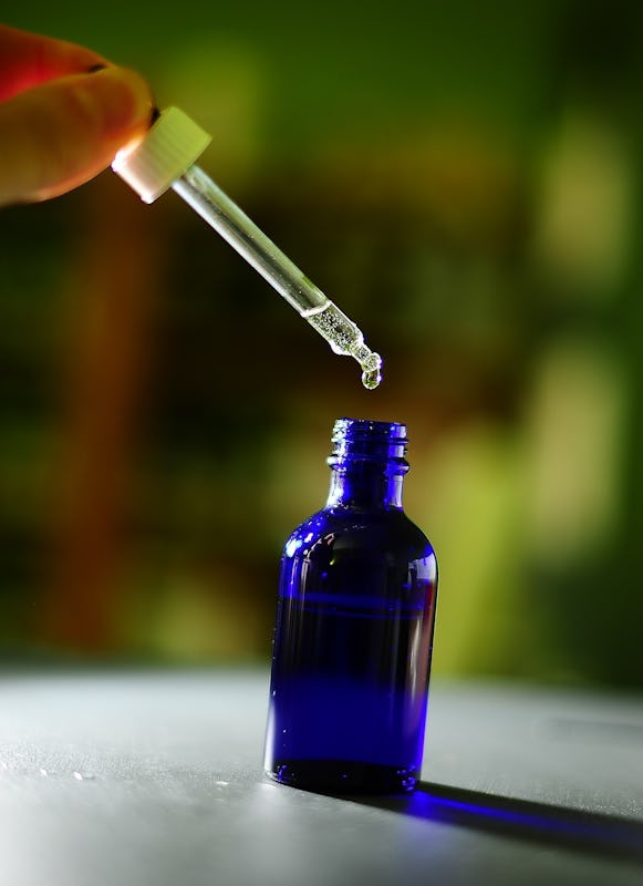 A pipette extracting LSD from a bottle for microdosing