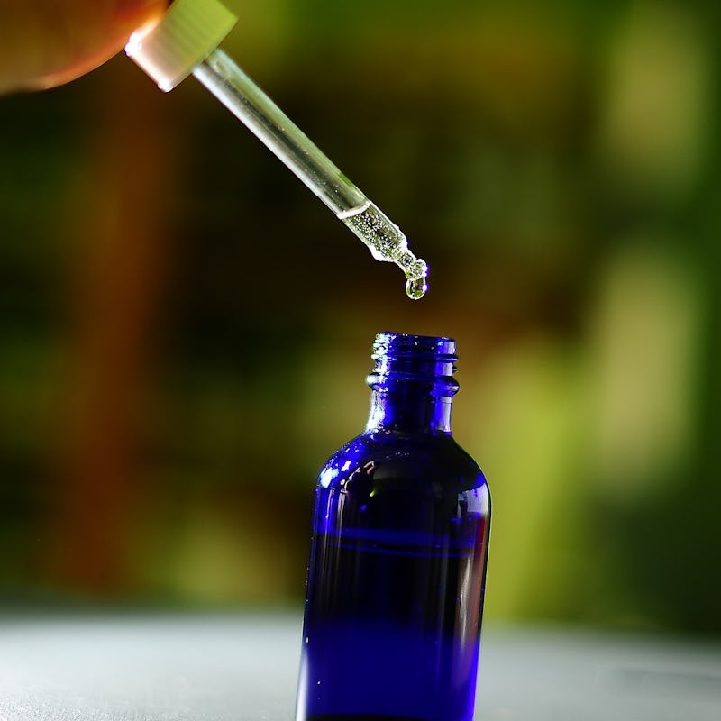 A pipette extracting LSD from a bottle for microdosing