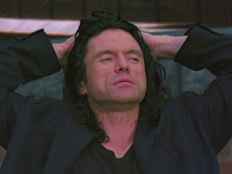 Tommy Wiseau from 'The Room' in a black suit with his hand on his head