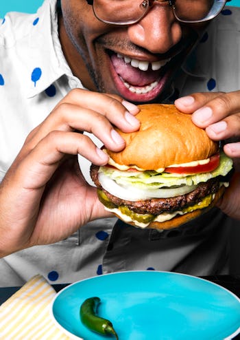 A man eating a plant-based Impossible Whopper Burger that has as many calories as a beef burger