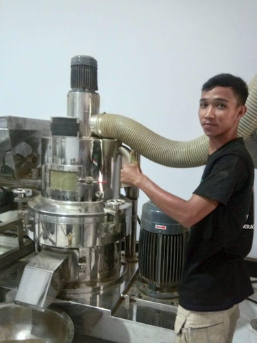 Rio Rinaldi, a kratom seller in Pontianak, Indonesia, with the kratom leaf grinder in his warehouse.