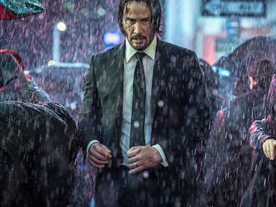 Keanu Reeves walking through a crowd in the rain in John Wick 4 