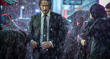 Keanu Reeves walking through a crowd in the rain in John Wick 4 