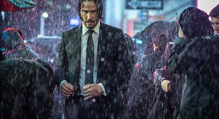 Keanu Reeves walking through a crowd in the rain in John Wick 4
