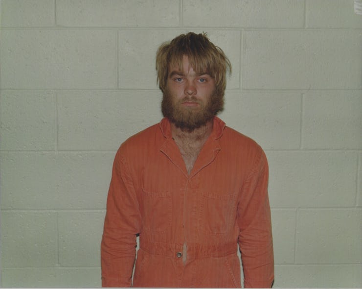 Steven Avery in prison in an orange jumpsuit against a white tile wall