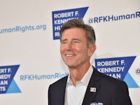 Matt McCoy in a black suit and a white shirt smiling at an event