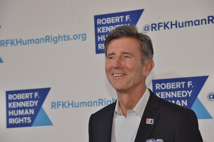 Matt McCoy in a black suit and a white shirt smiling at an event