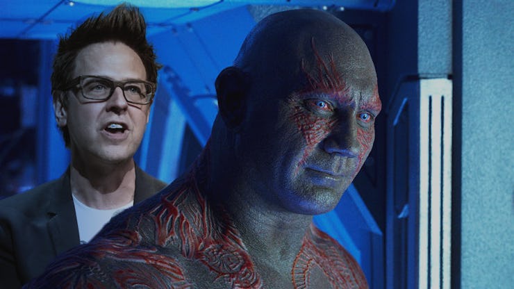 James gunn standing behind dave bautista as draxx