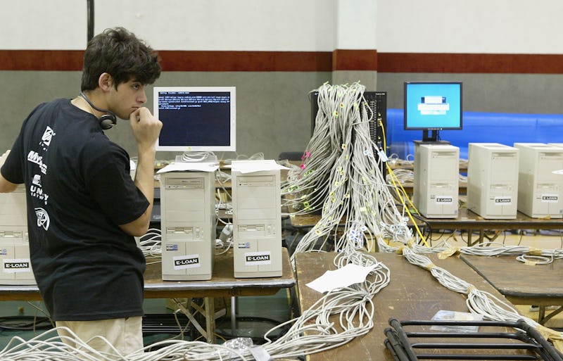 A boy standing next to a table with a computer