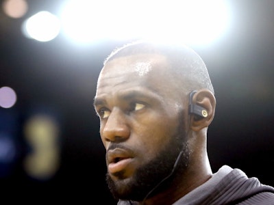 LeBron James wearing a black hoodie while listening to music on his earbuds