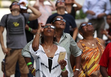 Three women looking up and watching the eclipse