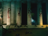 A screenshot from The Purge: Election Year with the word 'purge' written on building columns