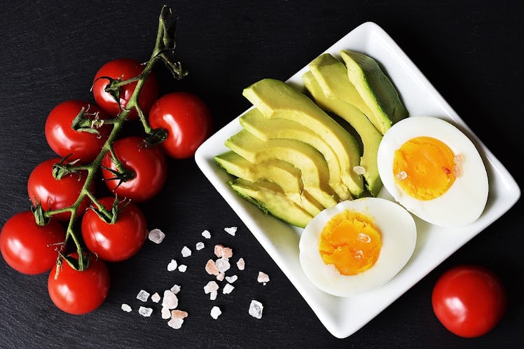 Avocado slices, a boiled egg, and cherry tomatoes 