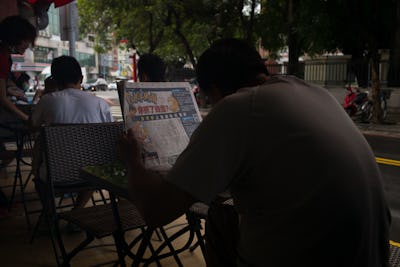 A man reading a newspaper article about "Pokémon Go"