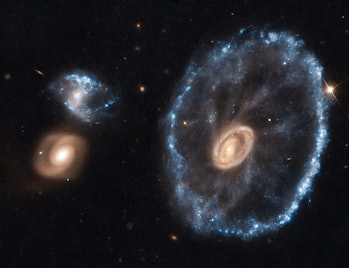 The Cartwheel Galaxy seen next to two smaller galaxies in the Sculptor constellation.