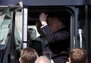 President Donald Trump sits in a truck and honks the horn in front of the White House.