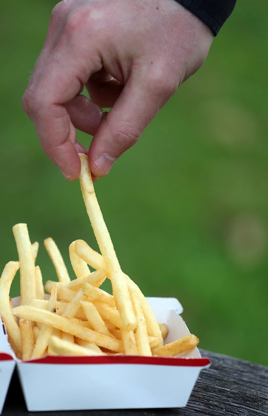 BRISTOL, ENGLAND - JANUARY 07: In this photo-illustration a man eats French fries purchased from a f...