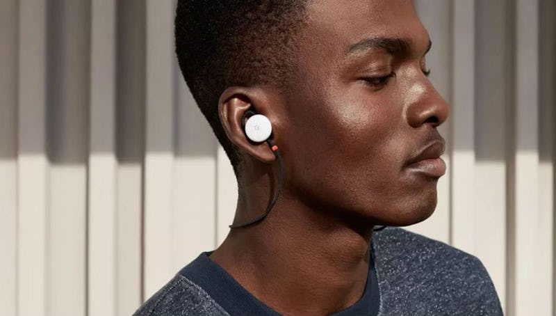 A man in a grey shirt with white pixel buds