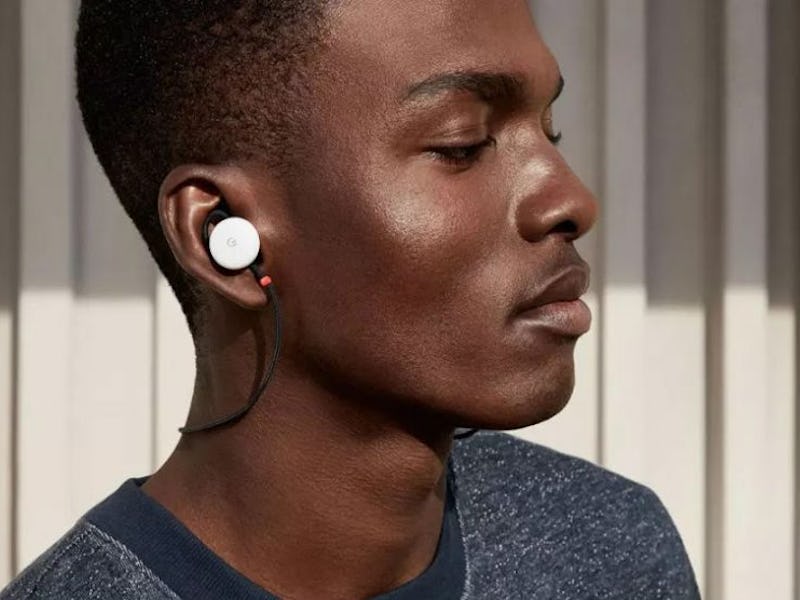 A man in a grey shirt with white pixel buds