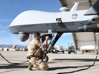 A man kneeling and taking a picture of an autonomous weaponry device