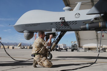 A man kneeling and taking a picture of an autonomous weaponry device