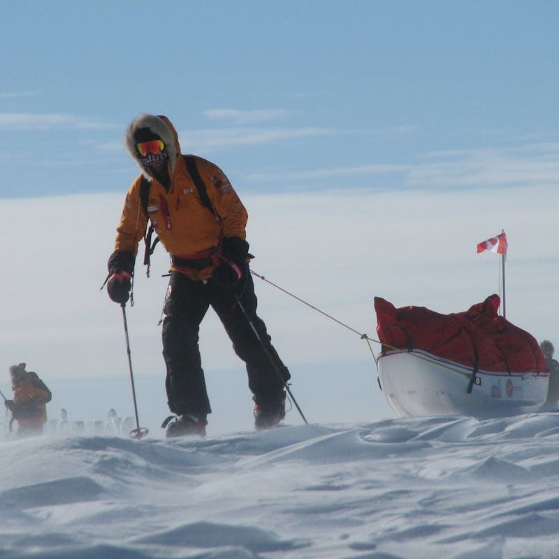 A motivated man exploring the South Pole on skis while dragging a ski bed