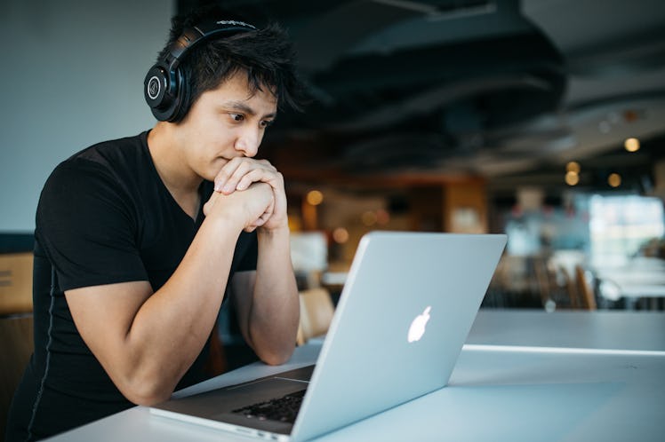 Man macbook headphones listening computer