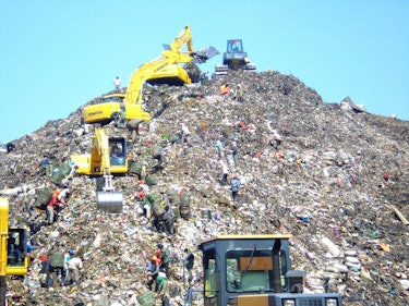Mountain of garbage in Bantar Gebang with some excavator (Indonesia).